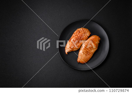 Delicious fresh grilled chicken fillet with spices and herbs on a dark concrete background 110729874