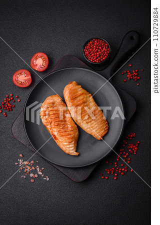 Delicious fresh grilled chicken fillet with spices and herbs on a dark concrete background Delicious fresh grilled chicken fillet with spices and herbs on a dark concrete background 110729884