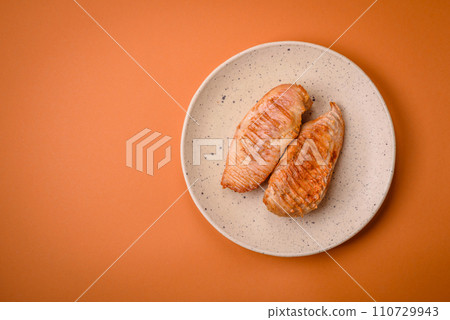 Delicious fresh grilled chicken fillet with spices and herbs on a dark concrete background 110729943