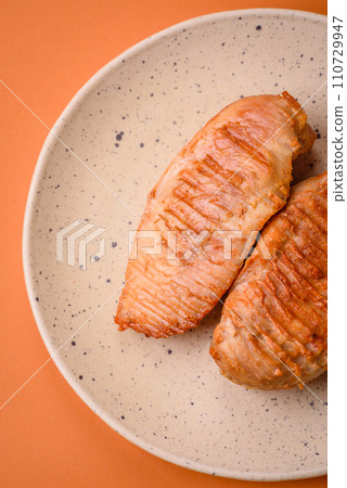 Delicious fresh grilled chicken fillet with spices and herbs on a dark concrete background Delicious fresh grilled chicken fillet with spices and herbs on a dark concrete background 110729947