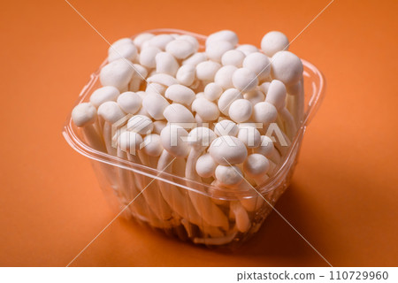 Small white edible beech mushrooms with salt and spices on a plain background 110729960