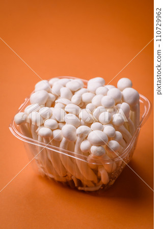 Small white edible beech mushrooms with salt and spices on a plain background Small white edible beech mushrooms with salt and spices on a plain background 110729962