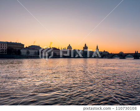 Prague bridge over a river with a city in the background 110730108
