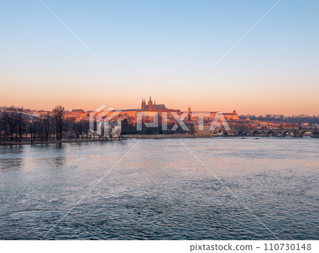Prague bridge over a river with a city in the background 110730148