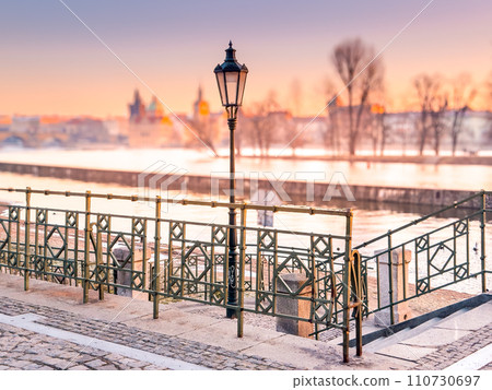 Prague bridge over a river with a city in the background 110730697