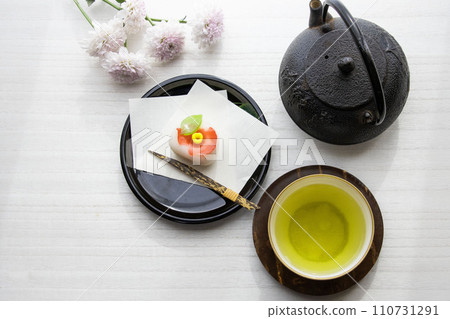 Elegant Japanese sweets and green tea on a black round plate Elegant Japanese sweets and green tea on a black round plate 110731291