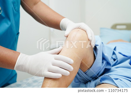 Doctor checking Asian elderly woman patient with scar knee replacement surgery in hospital. Doctor checking Asian elderly woman patient with scar knee replacement surgery in hospital. 110734175