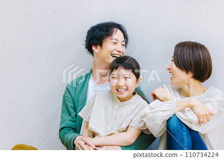 坐在客廳地板上的親密家庭 坐在客廳地板上的親密家庭 110734224