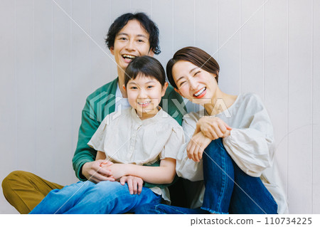 坐在客廳地板上的親密家庭 坐在客廳地板上的親密家庭 110734225