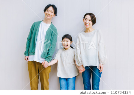 A close family holding hands in the living room A close family holding hands in the living room 110734324