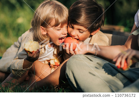 Cute little boys eating, enjoying tasty apples in garden. Organic fruits, home 110736172