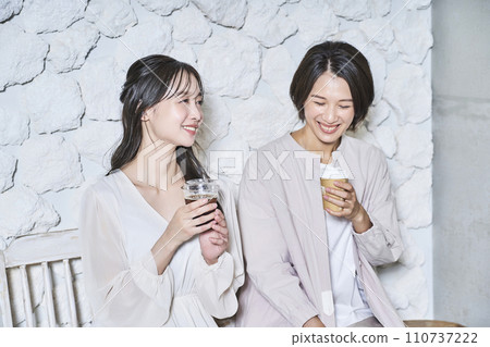 女人一邊喝咖啡一邊聊天 女人一邊喝咖啡一邊聊天 110737222