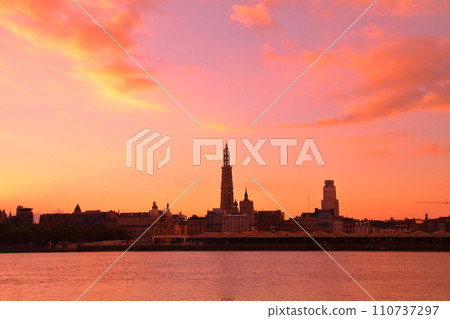 Silhouette of the city at sunrise from the opposite bank of the Escaut River flowing through Antwerp, Belgium, Western Europe 110737297