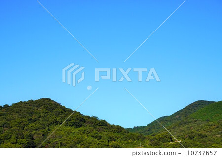 Full moon in the daytime visible between the mountains Full moon in the daytime visible between the mountains 110737657
