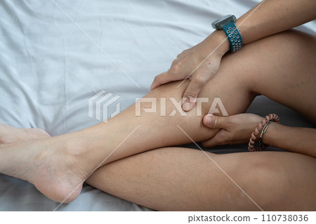 Female hands holding leg calves. Leg pain. Squeeze and massage to relax. Female hands holding leg calves. Leg pain. Squeeze and massage to relax. 110738036