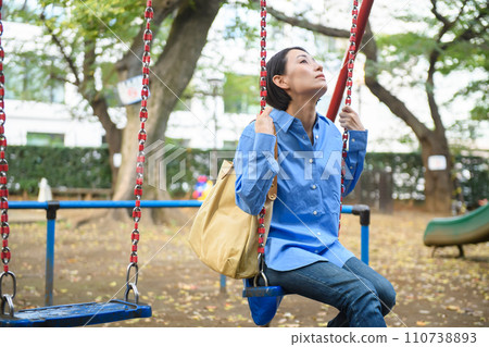 A woman killing time in the park 110738893