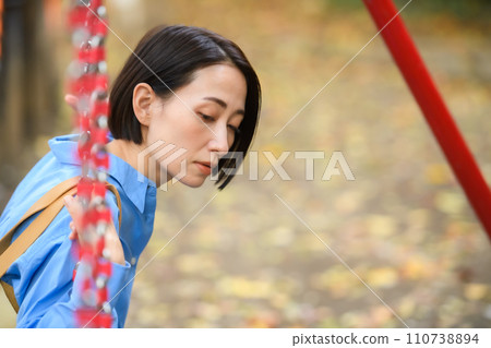 A woman killing time in the park 110738894