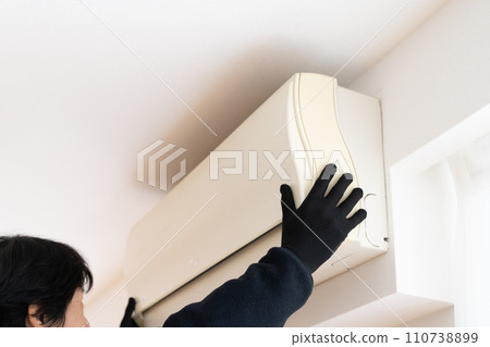 Hand wearing black work gloves removing air conditioner Hand wearing black work gloves removing air conditioner 110738899
