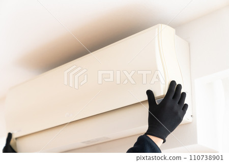 手戴黑色工作手套拆卸空調 110738901