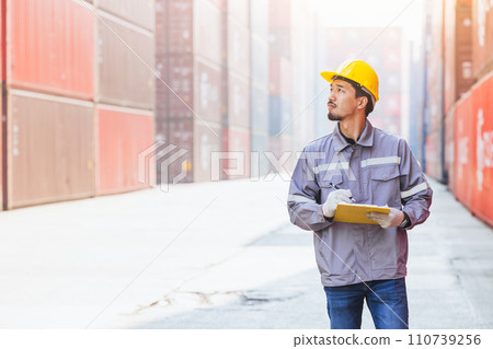Japanese male smart worker working in container port cargo. Japan shipping logistics industry customs staff. 110739256