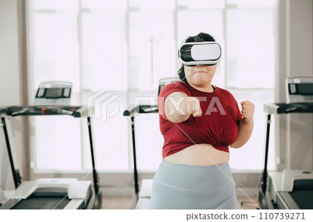 fat women with VR headset play visual reality sport game for exercise. people using modern technology for healtcare concept. 110739271