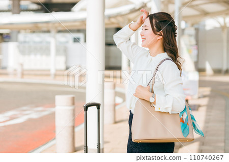 A business woman waiting for a bus or taxi at the station to go on a business trip A business woman waiting for a bus or taxi at the station to go on a business trip 110740267