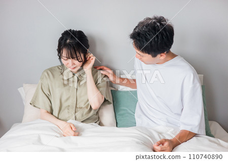 一名患有耳鳴、頭暈、聽力損失和中耳炎的女性和一名憂心忡忡的男性 110740890