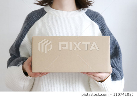 Woman holding a cardboard box luggage image Woman holding a cardboard box luggage image 110741085