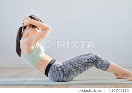 Woman training her abdominal muscles with crunches 110741313