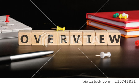 OVERVIEW the text of non-wooden cubes next to notepads, a calculator, a pen on a black background 110741831