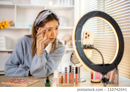 Beauty blogger, Woman teaching how to apply makeup, Record vlog streaming video, Live line on mobile phone. 110742041
