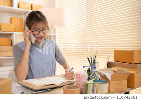 Sell products online, Young woman Multitasking: take orders from customers who call by phone, Young woman who has a lot of work and is very busy with work, Freelance working. 110742561