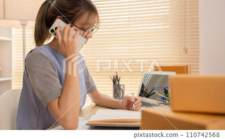 Sell products online, Close-up for hand holding a pen and taking notes in a notebook, Work for home. 110742568