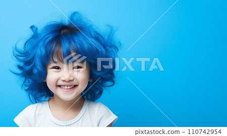 Cheerful girl with vibrant blue hair smiling in professional studio with monochrome background 110742954