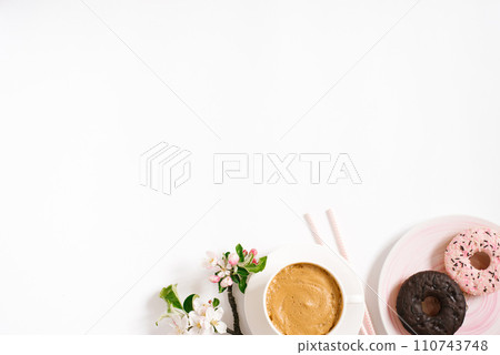 Stylish flat lay with cappuccino cup, apple blossoms, donuts on a white background with space copying. Morning breakfast or coffee break Stylish flat lay with cappuccino cup, apple blossoms, donuts on a white background with space copying. Morning breakfast or coffee break 110743748