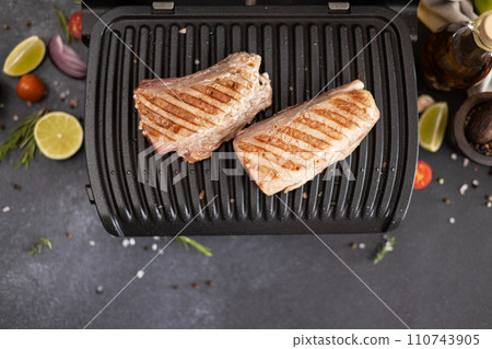 Two grilled pieces of tuna fillet on a electric grill at domestic kitchen 110743905