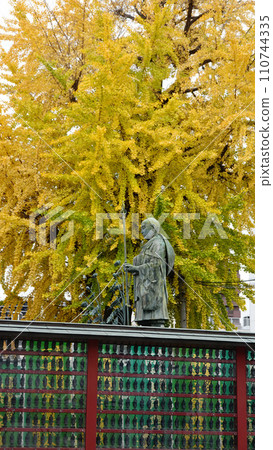 Osaka City: Statue of Kobo Daishi Sentai at Shitennoji Temple, founded by Prince Shotoku, standing in front of ginkgo trees in autumn leaves, 1857 110744335