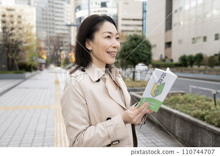 Smiling business woman looking at investment book Smiling business woman looking at investment book 110744707