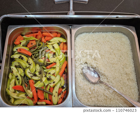 The restaurant has a variety of vegetables and rice in metal containers 110746023