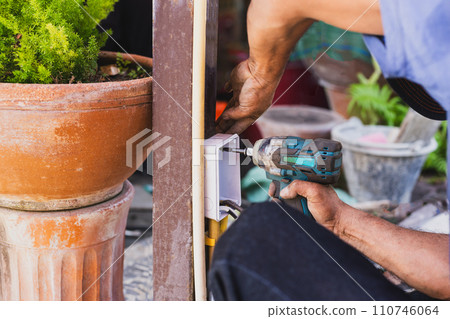 Electrician installing switches and sockets box on the metal pole. 110746064
