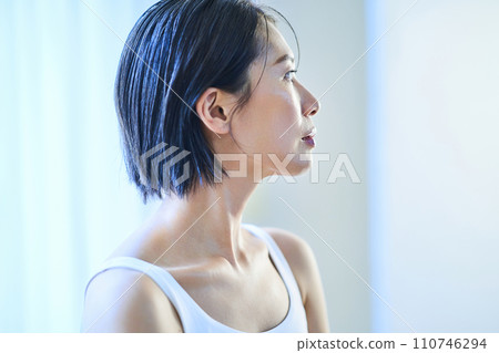 一個女人在窗邊放鬆,光線平靜 一個女人在窗邊放鬆,光線平靜 110746294