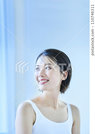 一個女人在窗邊放鬆，光線平靜 110746311