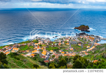 View of the village of Porto Moniz with volcanic lava pool, Atlantic ocean and green forest. Madeira Island, Portugal 110748591