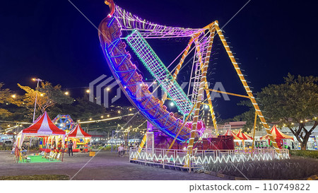 illuminated pirate ship swing boat ride in the amusement recreation park, Christmas market 110749822