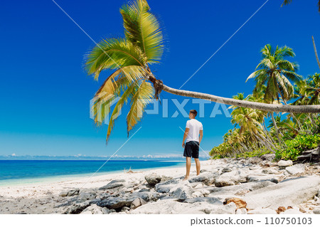A man staying on the beach. Slim man vacation on paradise beach 110750103