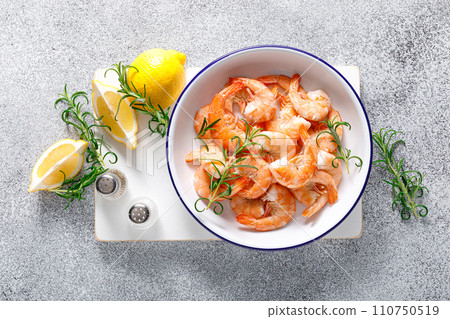 Shrimps with rosemary and lemon on a plate. Healthy food, seafood. Top view 110750519