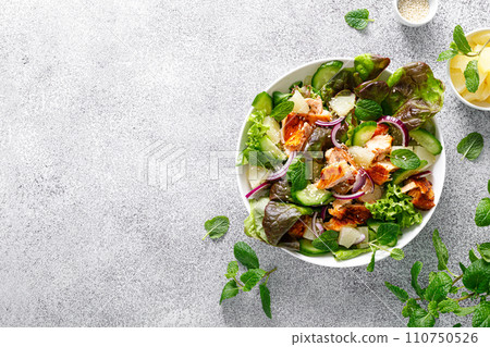 Salad with grilled salmon, fresh green salad leaves, cucumber, red onion, mint and pineapple. Healthy lunch salad for keto diet. Top view Salad with grilled salmon, fresh green salad leaves, cucumber, red onion, mint and pineapple. Healthy lunch salad for keto diet. Top view 110750526