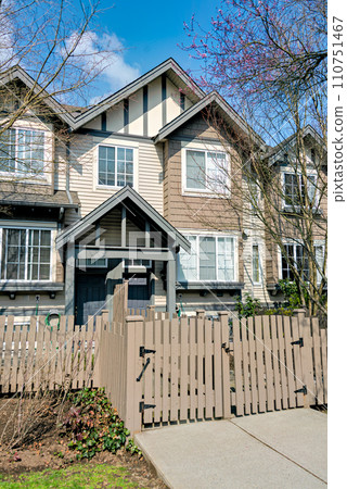 Residential townhouse entrance with wooden fence in front 110751467