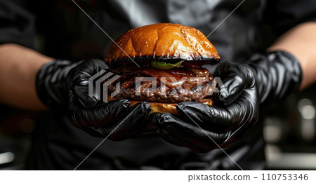 grilled hamburger in a black disposable glove grilled hamburger in a black disposable glove 110753346