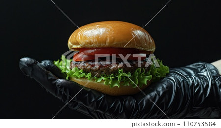 grilled hamburger in a black disposable glove grilled hamburger in a black disposable glove 110753584